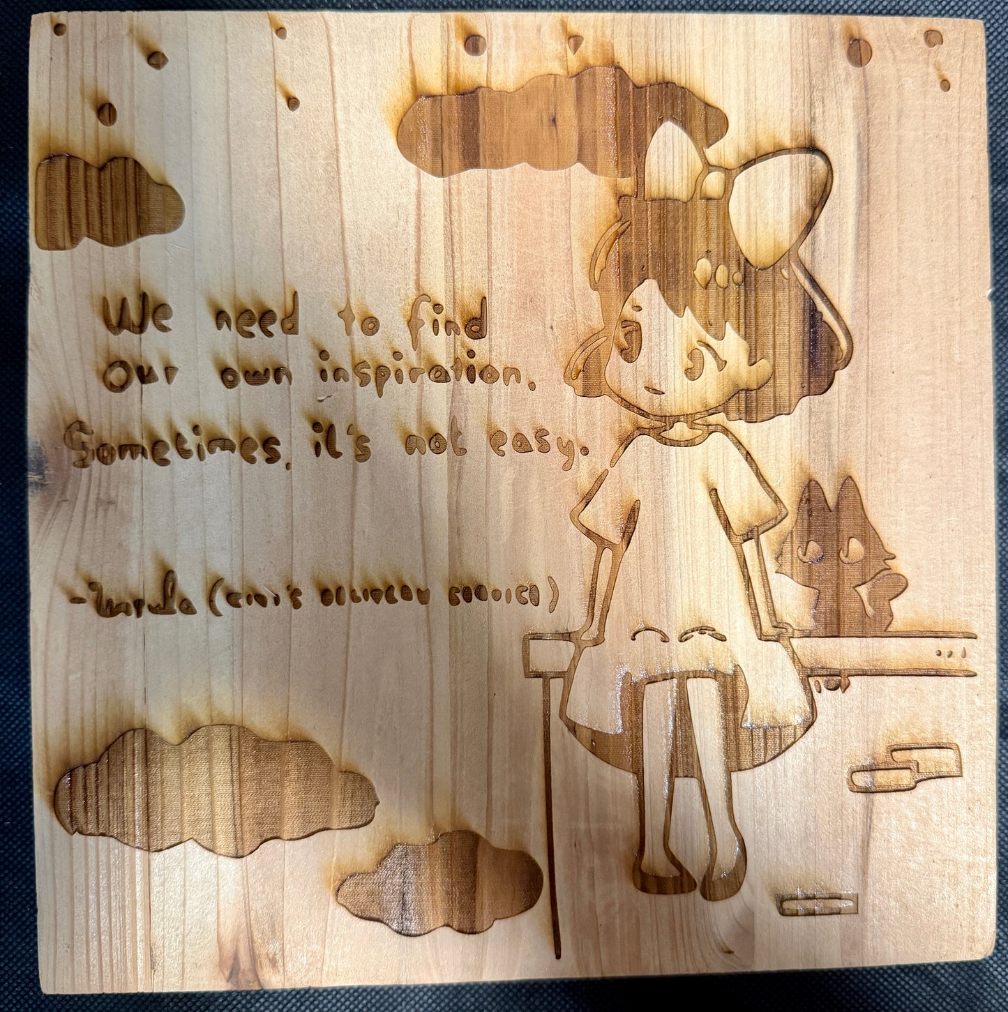 Wooden plaque with engraved girl and motivational quote on a wooden background