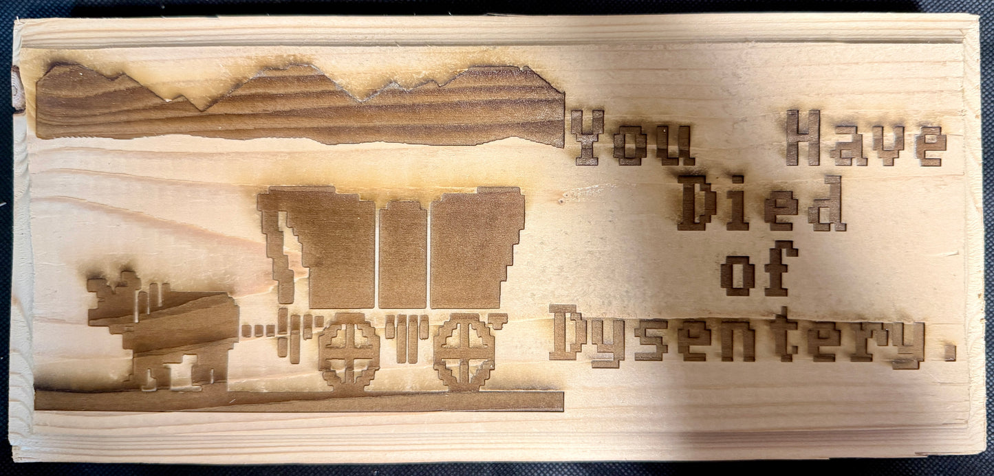 Wooden plaque with laser-engraved text and graphics on a black background