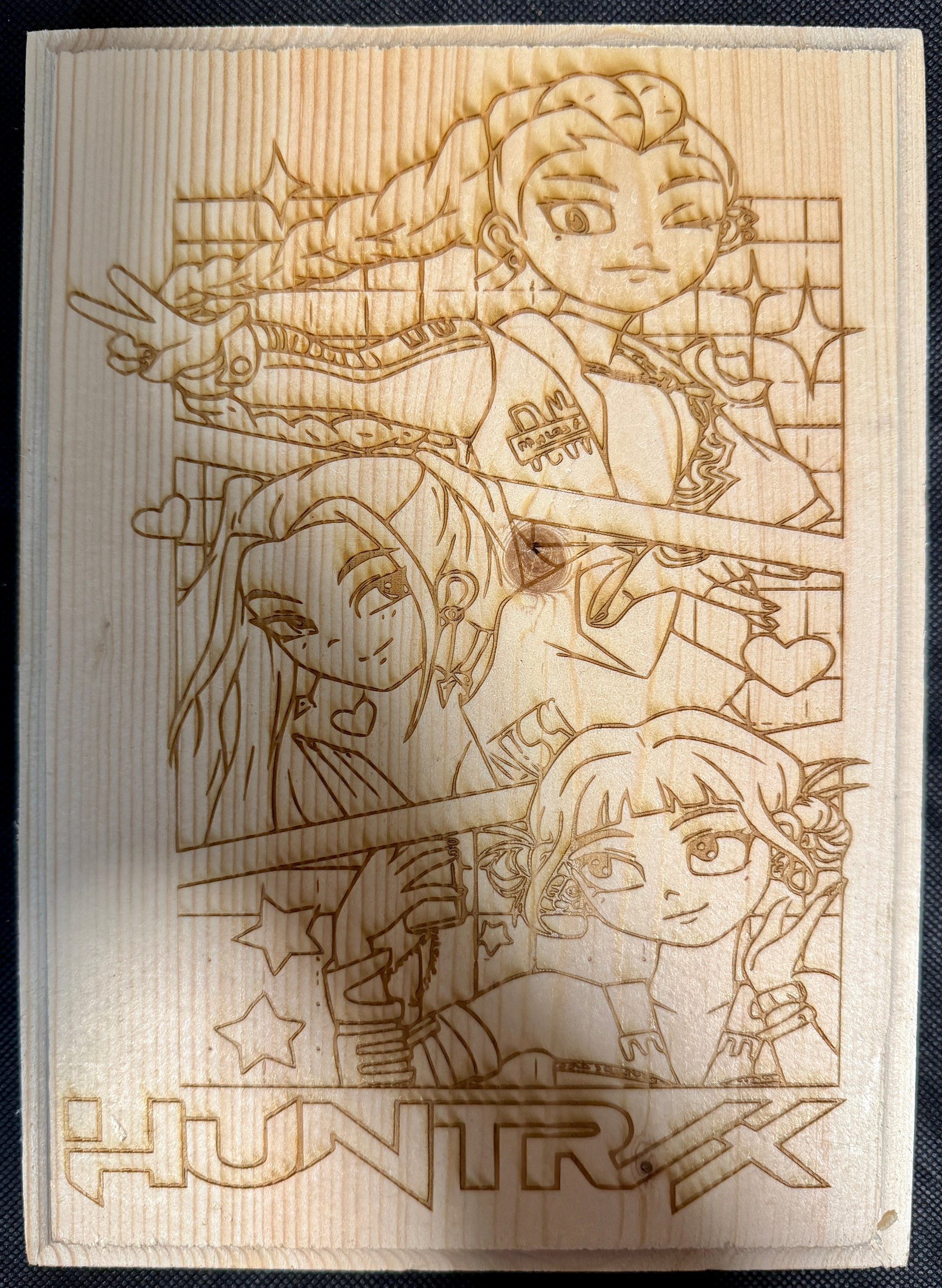 Wooden plaque with engraved illustration of characters and 'HUNTR' branding.