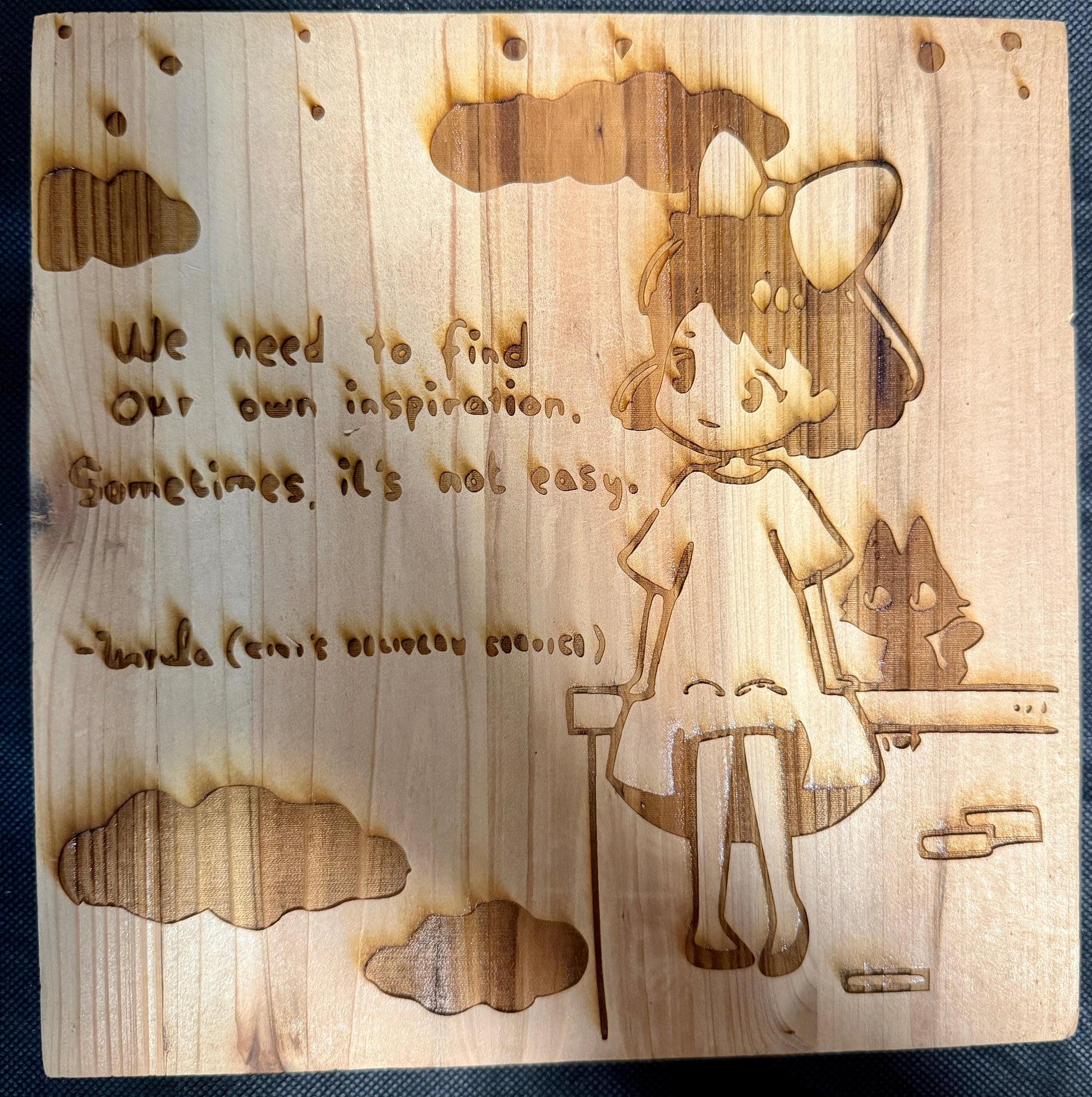 Wooden plaque with engraved girl and motivational quote on a wooden background
